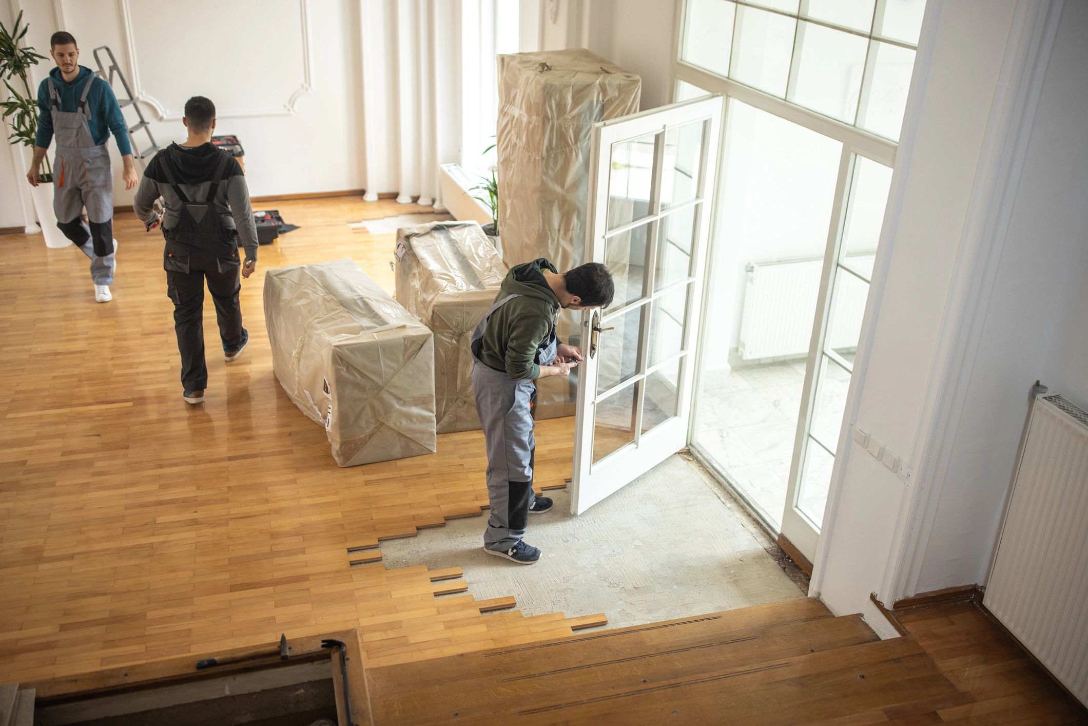 Movers handling large household items inside a home